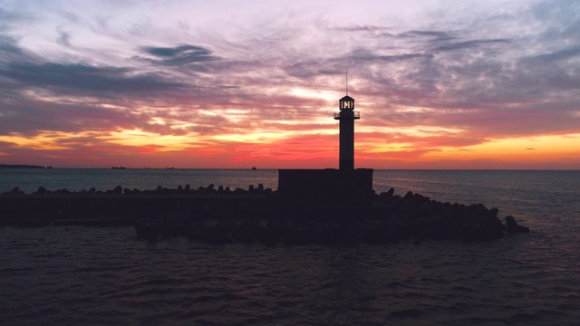 灯塔剪影和夕阳下的大海视频素材