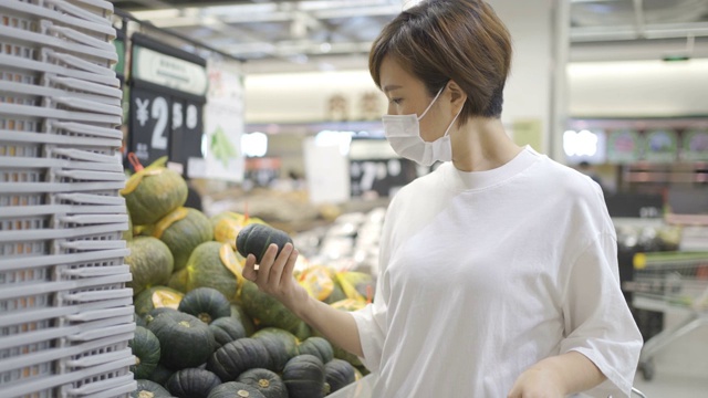 一个女人戴着一次性医用口罩在超市购物视频素材