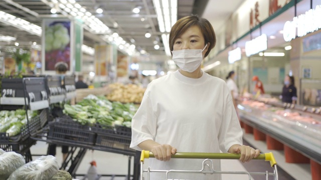 一个女人戴着一次性医用口罩在超市购物视频素材