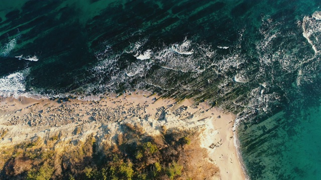 海浪撞击海滩岩石的鸟瞰图视频素材