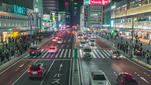 一段时间的推移，人群穿过街道与汽车交通在东京新宿，晚上，日本视频素材