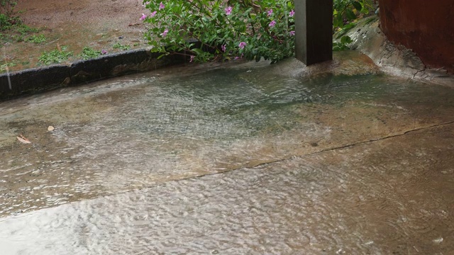 雨水打在破旧的水泥地板上，阳光柔和。4 k。视频下载