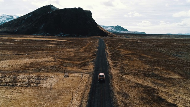 航拍跟踪一辆汽车沿着土路行驶在冰岛的风景，冰岛视频素材