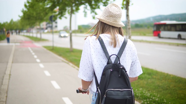 年轻漂亮的女人骑着滑板车视频素材