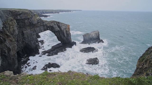 威尔士彭布罗克郡海岸国家公园，海浪拍打着绿桥视频素材