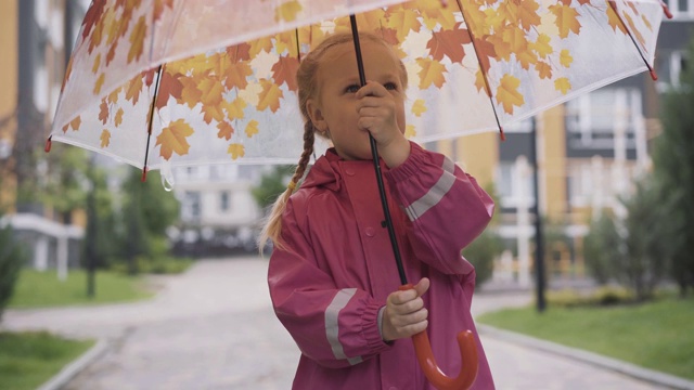 快乐的白人小女孩在户外纺伞。雨后可爱的孩子在享受春天或秋天的一天。欢乐，童年，幸福，生活方式。视频素材