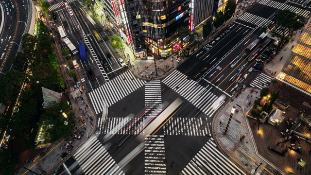 日本东京银座路十字路口夜晚拥挤的人群和汽车的时间流逝视频下载