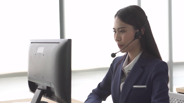 亚洲女性呼叫中心用窗光与客户交谈视频素材画面2