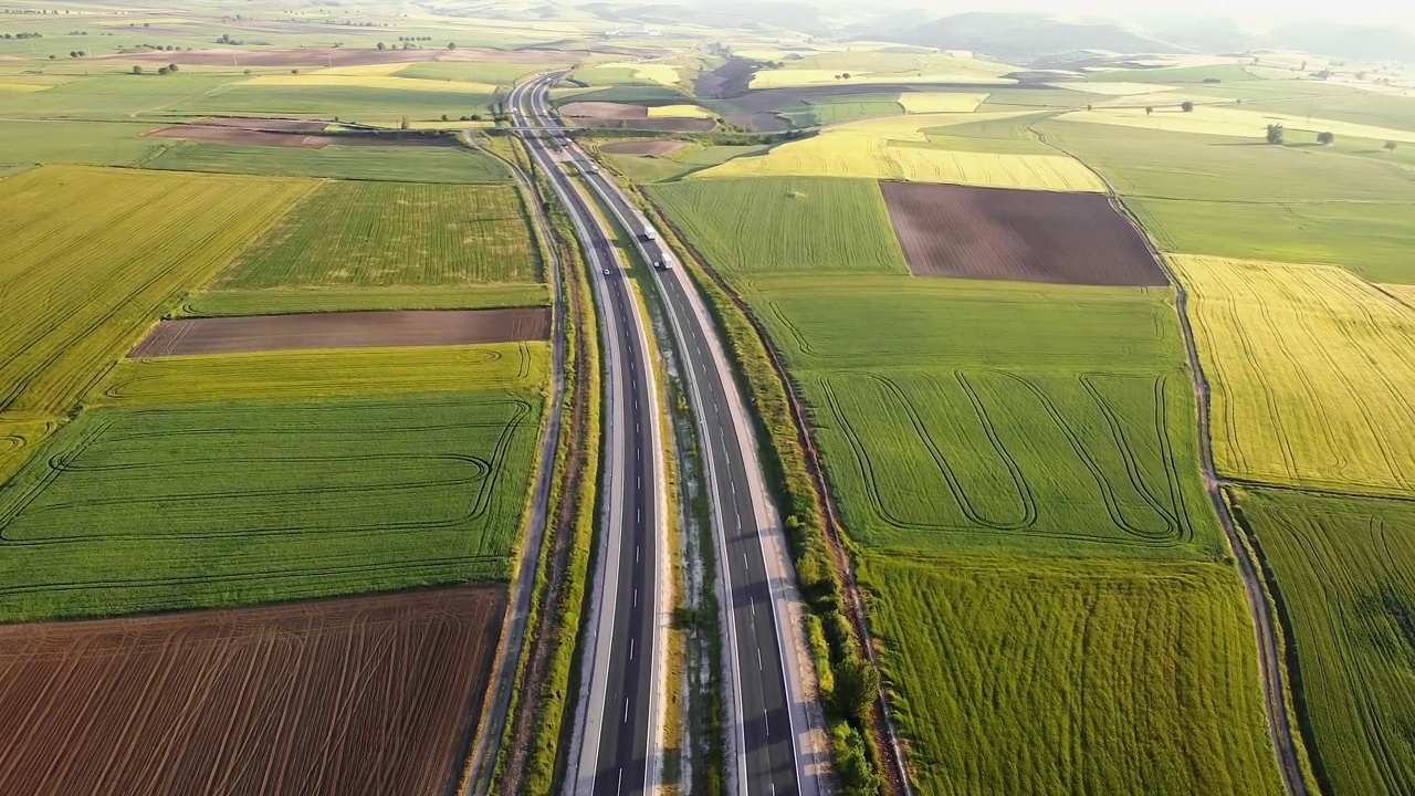 公路交通与乡村风光。郊区公路上有轿车和卡车。旅游和运输。鸟瞰图视频素材