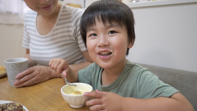 小儿子在饭厅吃冰淇淋，妈妈正坐在一起视频素材画面3