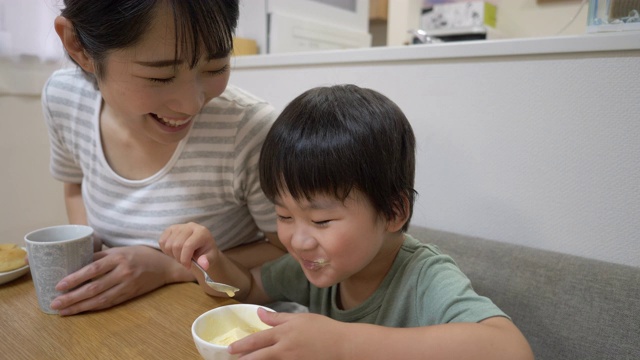 小儿子在饭厅吃冰淇淋，妈妈正坐在一起视频素材画面4
