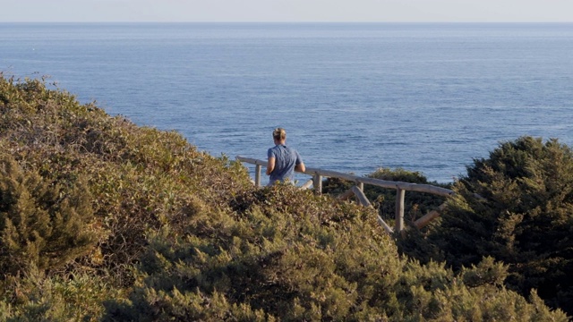 一名男子正在晨跑，周围是令人惊叹的海岸风景视频素材