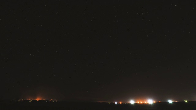 夜晚星空与发光的星星在景观与城市灯光。地上的星空视频素材