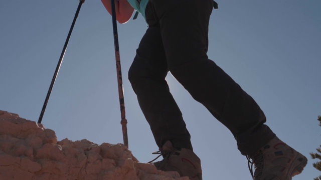 穿靴子的脚登山运动员游客爬上山岩太阳照过腿视频素材