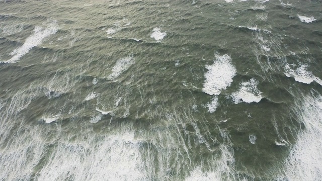 无人机拍摄草地和海浪形成的海水视频素材