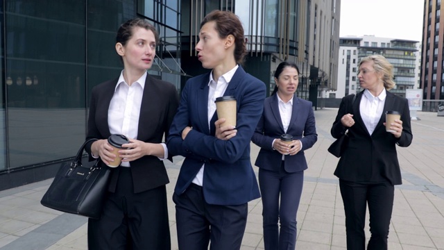 四个白人女同事在户外散步。商务女性在公司中心公司大楼里走来走去。女老板谈论合作未来计划讨论休息时间视频素材画面1