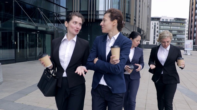 四个白人女同事在户外散步。商务女性在公司中心公司大楼里走来走去。女老板谈论合作未来计划讨论休息时间视频素材画面3