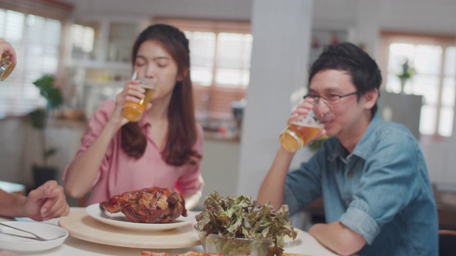 快乐的亚洲朋友享受啤酒在家里，朋友用餐和聚会的概念视频素材