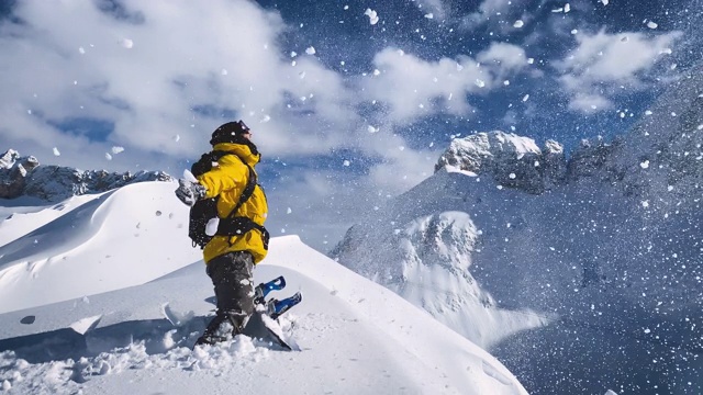 在一个阳光明媚的冬日，滑雪者站在雪山顶上，向空中抛雪，满心欢喜视频素材