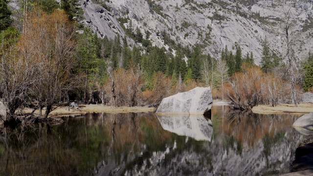 在一个阳光明媚的冬天，放大优山美地(Yosemite)镜湖中的一块大石头视频素材