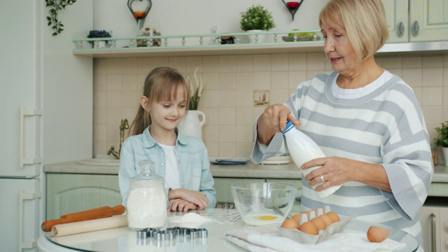 慈祥的奶奶教孙女如何做糕点，还往碗里放食材视频素材