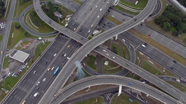 日落时分俯瞰莫斯科多层次交通交汇处上空的航班。城市高速公路上的汽车交通。无人机拍摄的城市景观视频素材