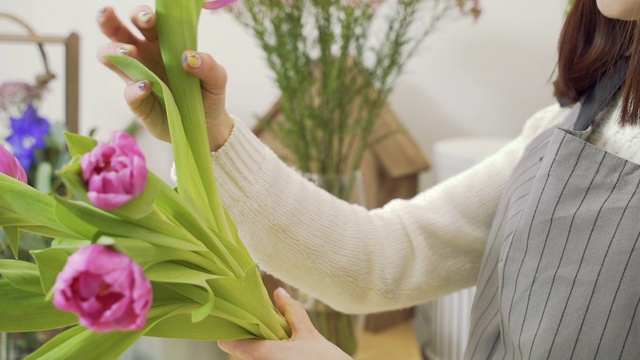 特写花店或花坊中装饰郁金香花束的女花匠之手视频素材