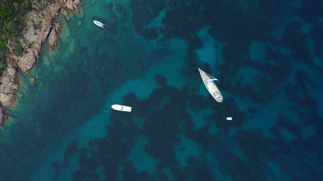 从上面看，一些船漂浮在美丽的，绿松石海洋上的令人惊叹的鸟瞰图。意大利撒丁岛翡翠海岸。视频素材