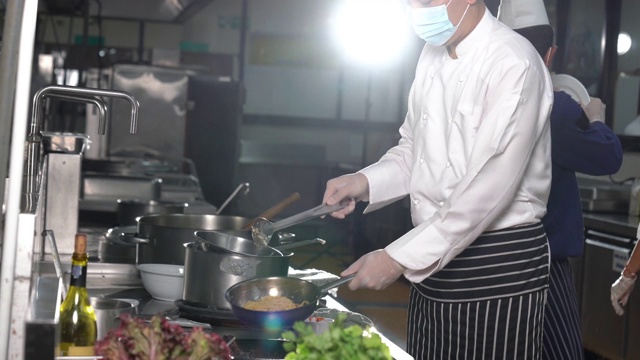 在酒店餐厅厨房里准备食物的厨师团队。视频素材画面1