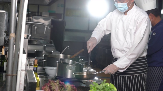 在酒店餐厅厨房里准备食物的厨师团队。视频素材画面3