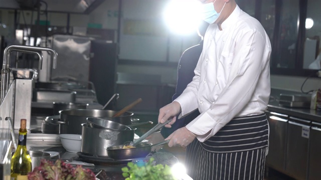 在酒店餐厅厨房里准备食物的厨师团队。视频素材画面4