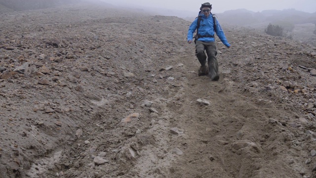 厄瓜多尔，一个雾蒙蒙的天气，一名男子从火山山坡上跑下来视频素材