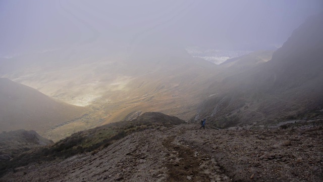 一个男人跑下火山山坡的风景，在一个雾霾和阴沉的日子，厄瓜多尔视频素材