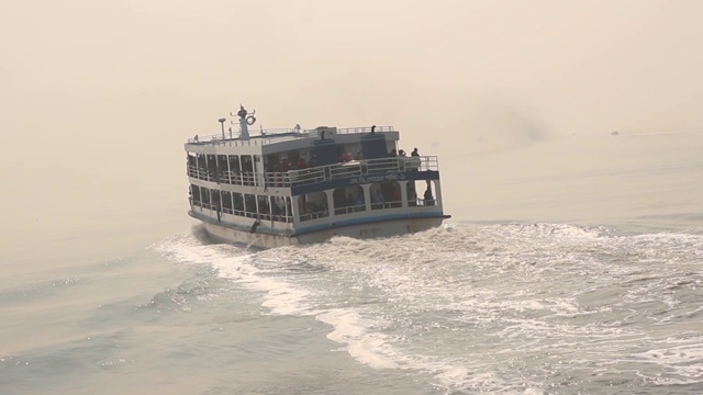 黄昏的风景移动的旅游船和跟随水船后面运行的海鸥在深海。视频素材