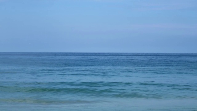 湛蓝的海水和平静的海浪涟漪在缕缕的天空背景视频素材