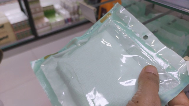 在药店购买医用绷带在智能手机上的慢动作拍摄视频素材画面1