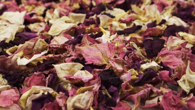 旋转一堆干玫瑰花瓣。花的背景。视频素材画面1