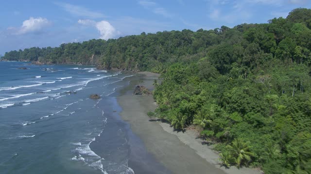 海浪撞击海岸线与岩石形成的鸟瞰图Llorona海滩在科尔科瓦多国家公园，哥斯达黎加。视频素材