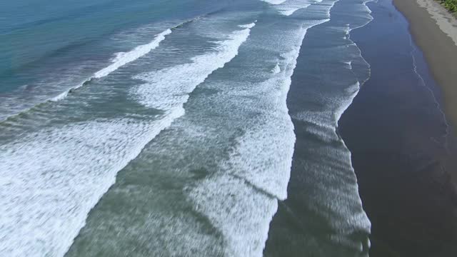 从太平洋海浪中空中拍摄，揭示哥斯达黎加的岩石构造、岛屿和森林覆盖的海岸线。视频素材