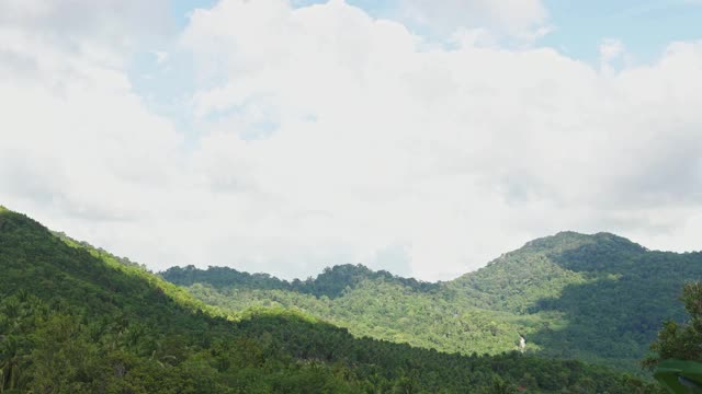 长时间的山顶有绿色的热带森林。云飞快地飞逝。一个晴朗的晴天。蓝色的天空。视频素材