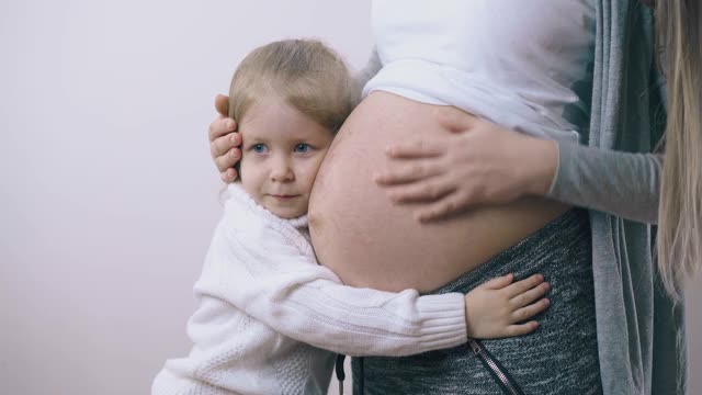 孕妇抱着小女孩在轻墙视频素材