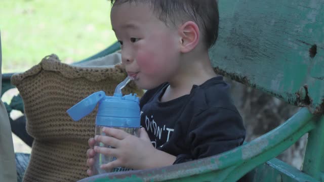 亚洲男孩喝水后，他玩视频素材