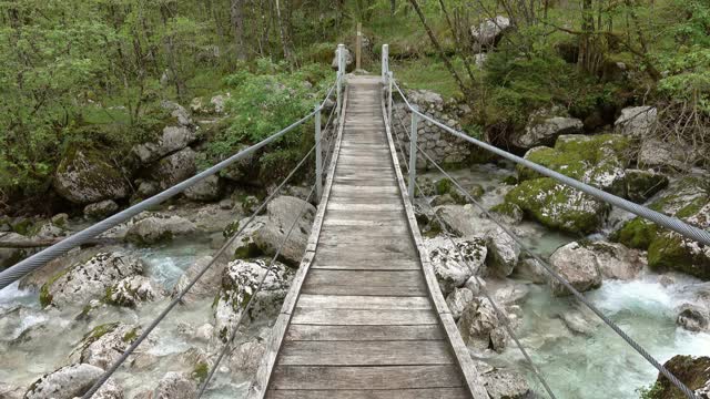 一座通过山间河流的悬索桥视频素材