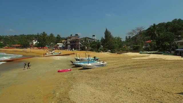 空中向前:斯里兰卡加勒，人们在海滩上迎着天空享受阳光视频素材