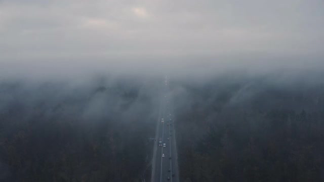 一个阴沉的秋天早晨，从空中俯瞰一条雾蒙蒙的高速公路。视频素材