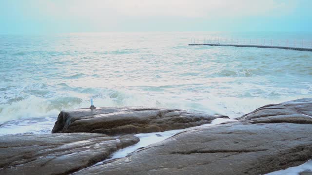 海浪拍打着海滩上的岩石。视频素材