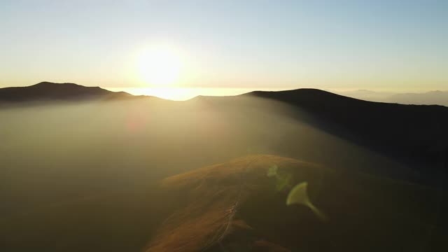 在夕阳柔和的光线中飞过秋山。风景优美的鸟瞰图，田园起伏的丘陵，喀尔巴阡山脉的秋天景观在日落视频素材