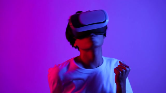 戴着虚拟眼镜的男人在霓虹灯下欢呼视频素材画面3