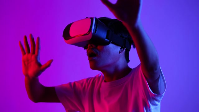 戴着VR眼镜的男子双手在空中触摸视频素材画面1