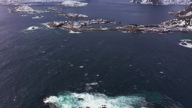 哈姆诺伊村，公路和山脉在冬天。挪威海和暴风雨的天空。摩斯基尼，罗浮敦群岛，挪威风景。鸟瞰图。无人机向前飞，向上倾斜。揭示拍摄视频素材